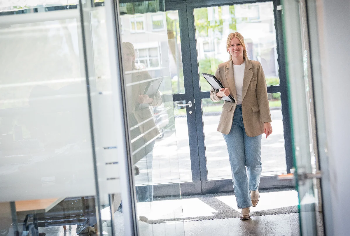 Casemanager van Prevenzo loopt met een dossier het kantoor binnen