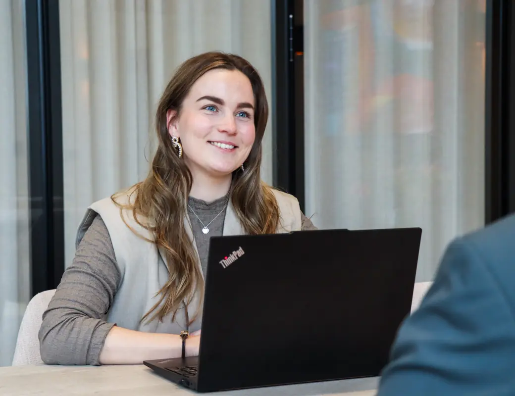 Casemanager van Prevenzo in gesprek aan tafel, met het dossier op de laptop