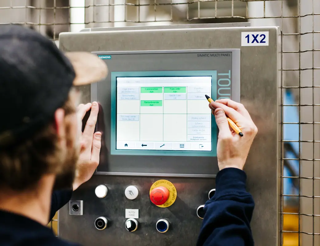 Operator bedient een machinepaneel op de productievloer