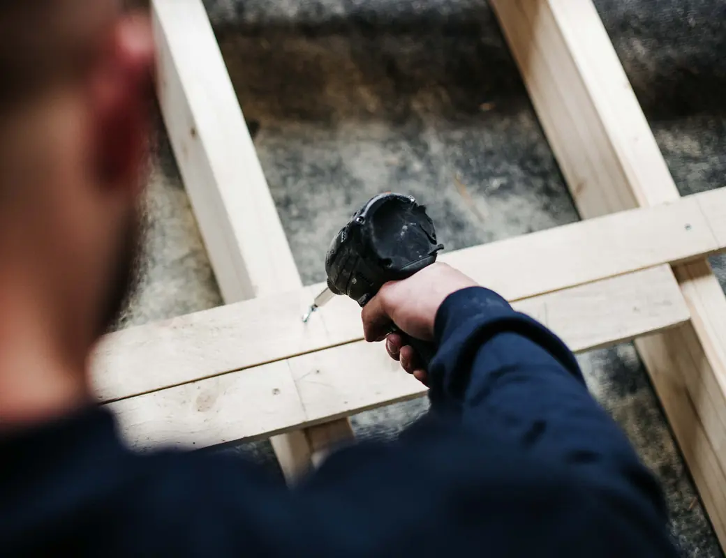 Vakman schroeft een houten frame in elkaar in de werkplaats